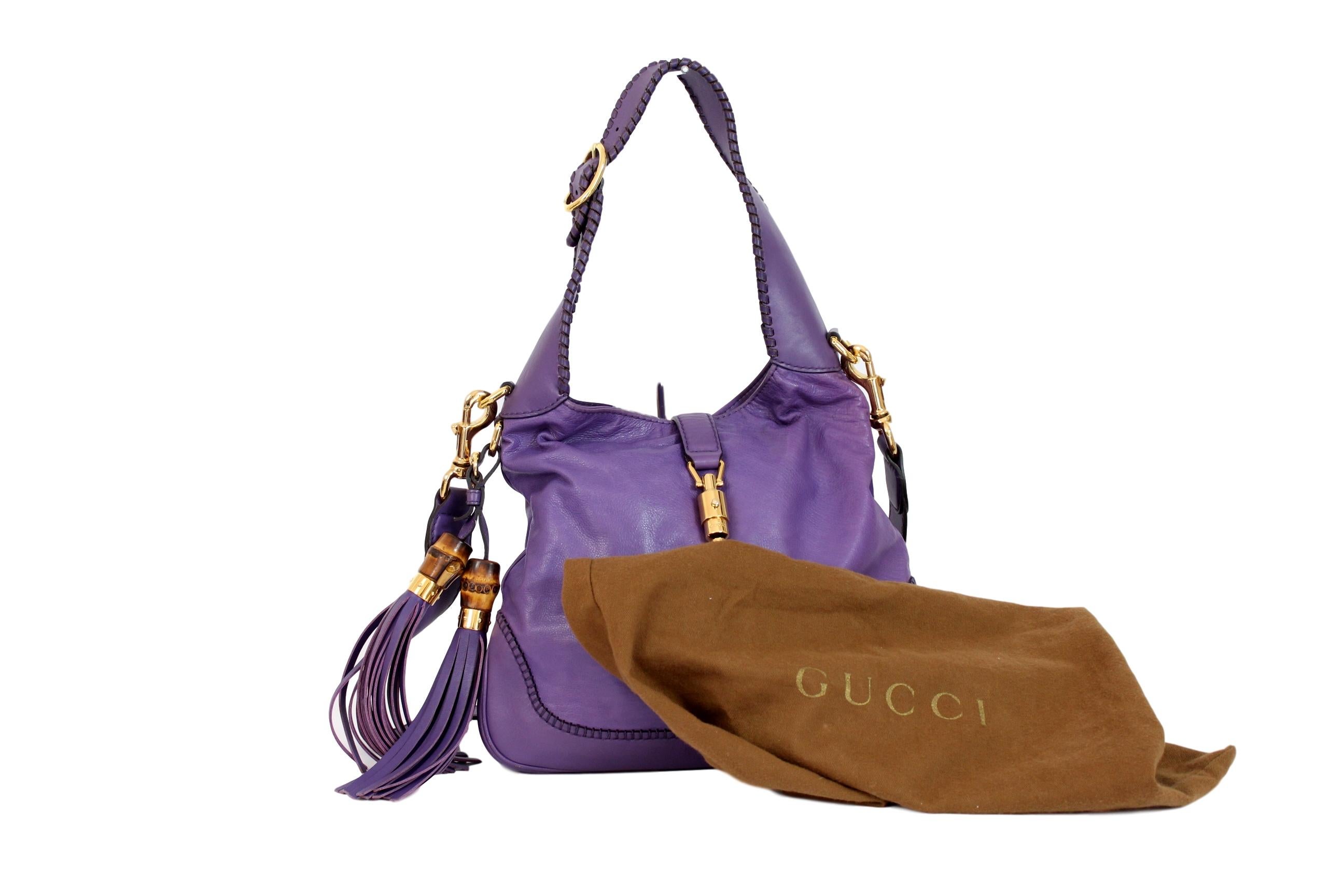Gucci Jackie 2000s bag. Purple color with gold-colored details and bamboo tassels and fringes. Piston hook closure. It can be carried either on the shoulder with an adjustable shoulder strap or by hand. Inner pockets. 100% leather. Made in Italy.