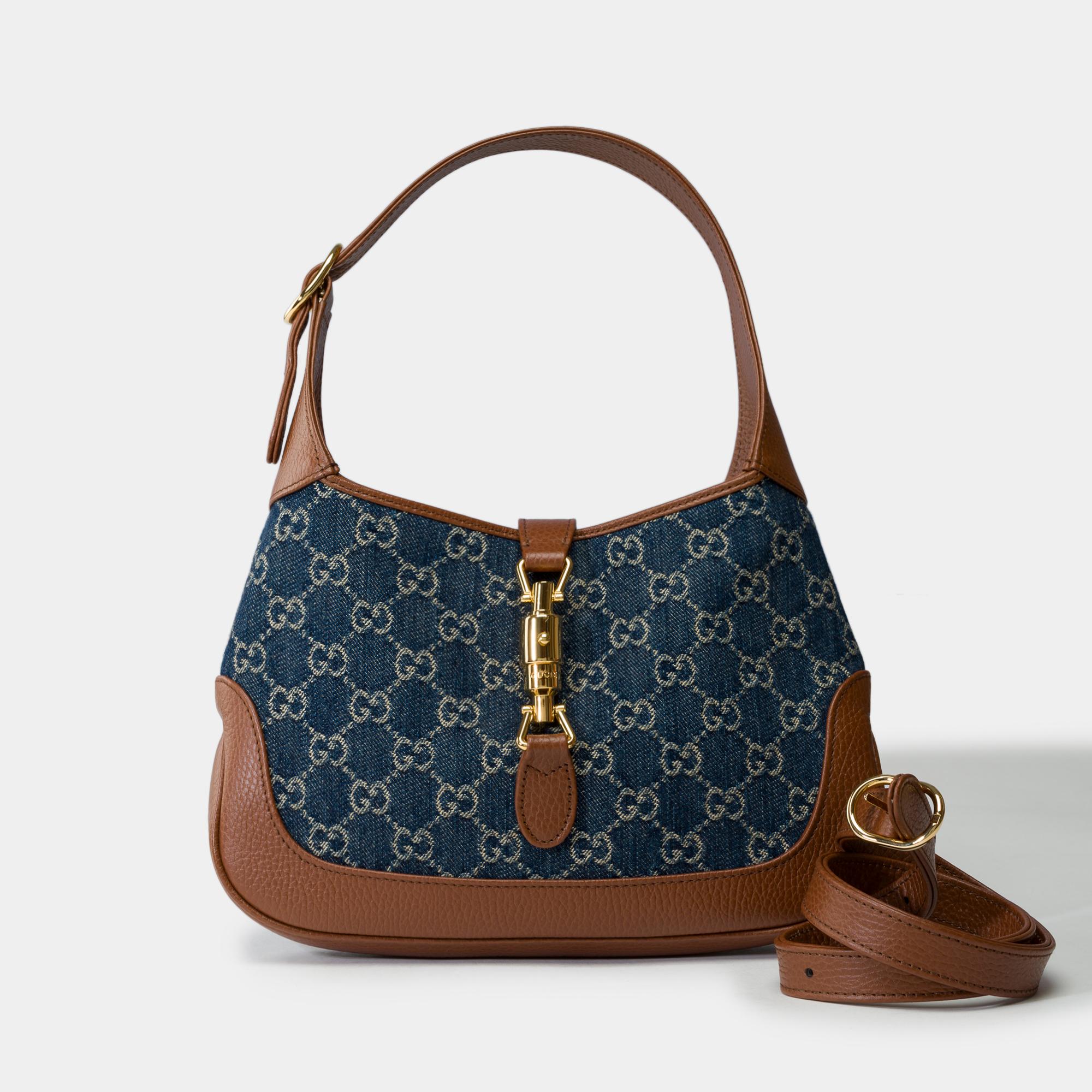 Gucci​ ​Jackie​ ​Small​ ​shoulder​ ​bag​ ​in​ ​brown​ ​leather​ ​and​ ​blue​ ​denim​ ​with​ ​monogram​ ​pattern,​ ​gold​ ​metal​ ​trim,​ ​handle​ ​and​ ​shoulder​ ​strap​ ​in​ ​brown​ ​leather​ ​removable/​ ​adjustable​ ​for​ ​hand​ ​or​ ​shoulder​