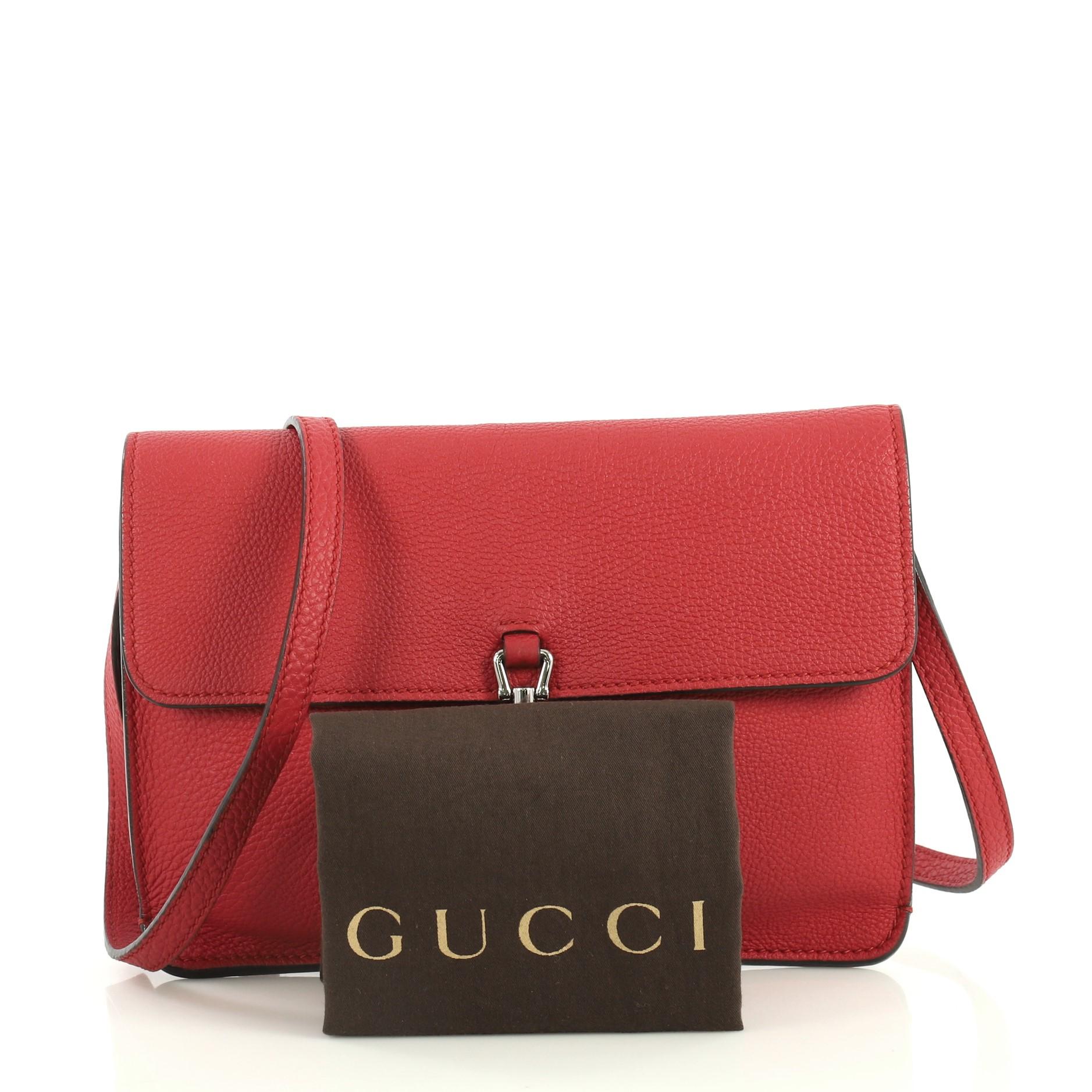 This Gucci Jackie Soft Convertible Clutch Leather Mini, crafted from red leather, features frontal flap, long adjustable strap and silver-tone hardware. Its pistol lock closure opens to a red suede and leather interior with slip pocket. 

Estimated