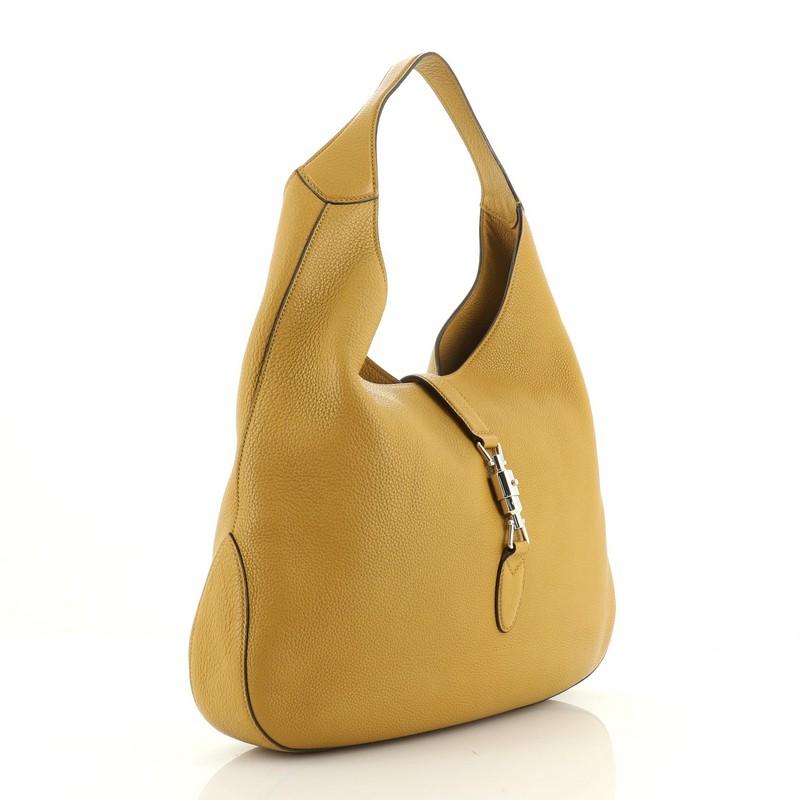 This Gucci Jackie Soft Hobo Leather, crafted from yellow leather, features a single loop leather handle and silver-tone hardware. Its piston lock closure opens to a neutral suede interior. 

Estimated Retail Price: $2,990
Condition: Good. Creasing