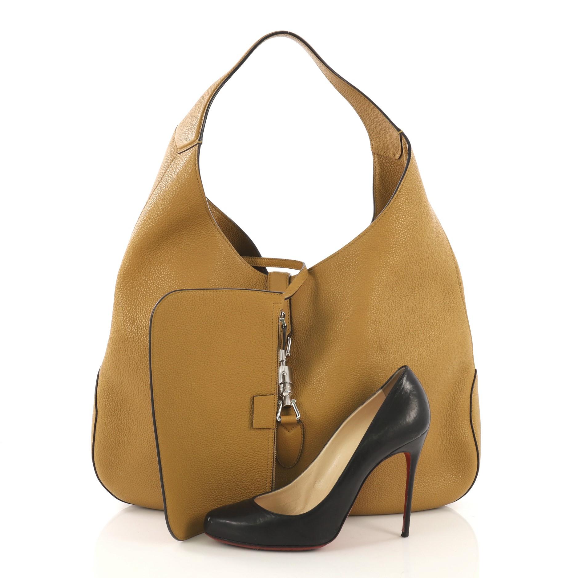 This Gucci Jackie Soft Hobo Leather, crafted from yellow leather, features a single loop leather handle, subtle imprinted Gucci logo at the front and silver-tone hardware. Its piston lock closure opens to a beige suede interior. **Note: Shoe