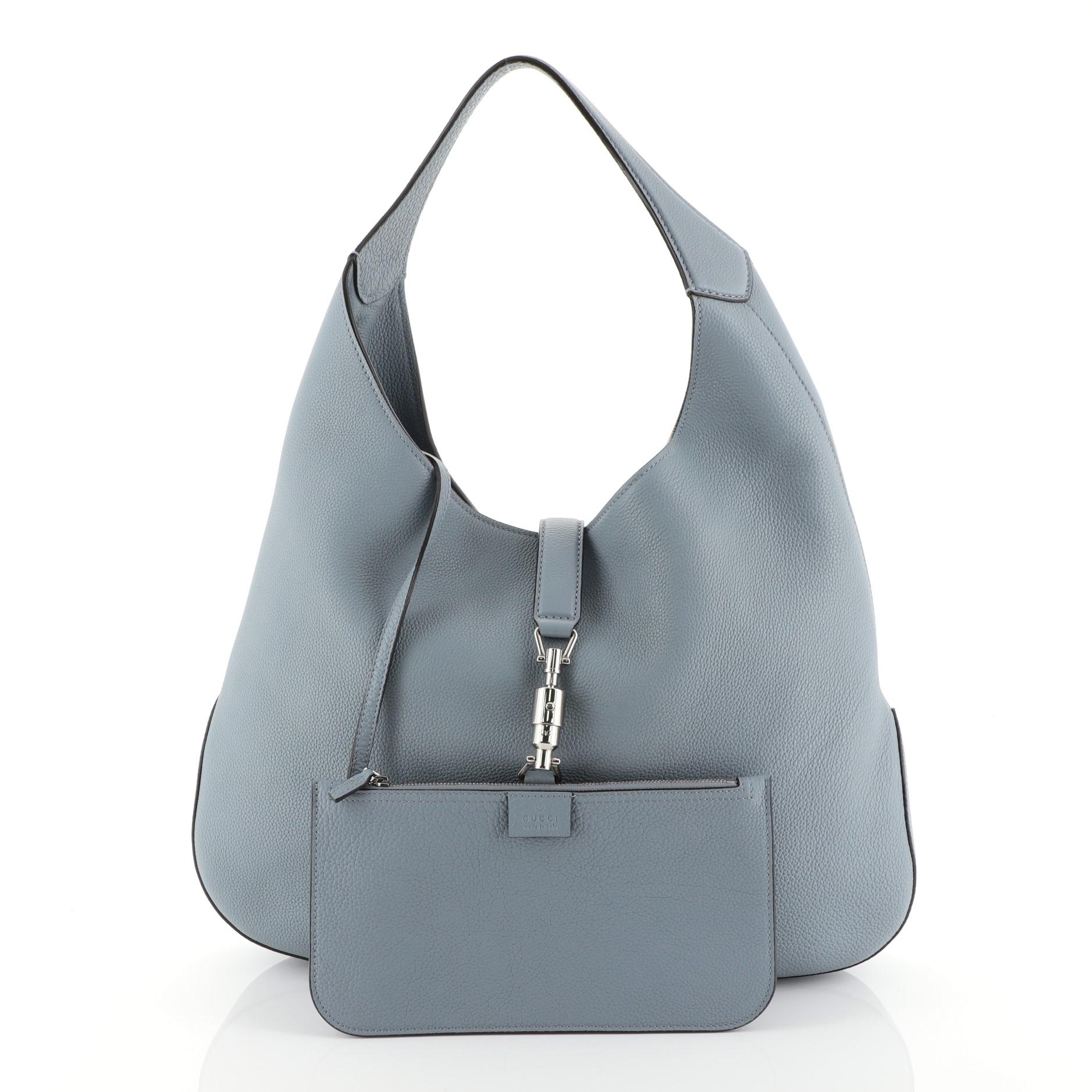 This Gucci Jackie Soft Hobo Leather, crafted from blue leather, features a single loop leather handle and silver-tone hardware. Its piston lock closure opens to a blue suede interior. 

Estimated Retail Price: $2,990
Condition: Excellent. Minimal