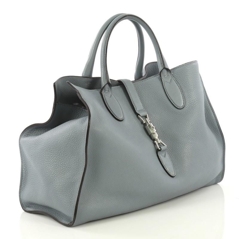 This Gucci Jackie Soft Tote Leather Large, crafted from blue leather, features dual rolled handles and silver-tone hardware. Its piston-lock closure opens to a blue suede interior with side zip pockets. 

Estimated Retail Price: $2,990
Condition: