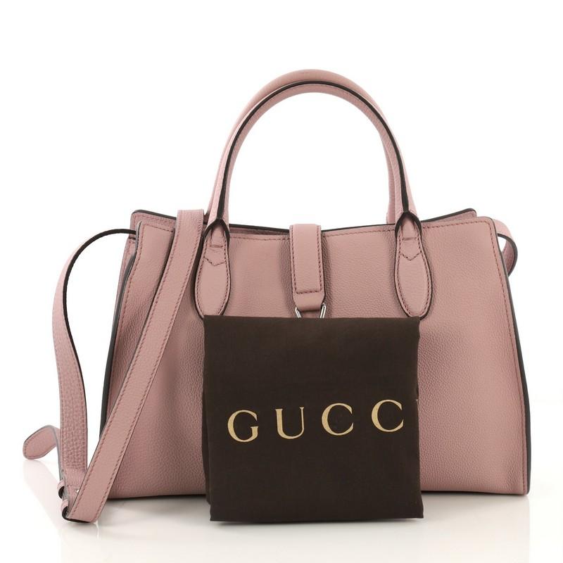 This Gucci Jackie Soft Tote Leather Small, crafted from mauve leather, features dual rolled handles and silver-tone hardware. Its piston-lock closure opens to a mauve suede interior with side zip pockets. 

Estimated Retail Price: $2,300
Condition: