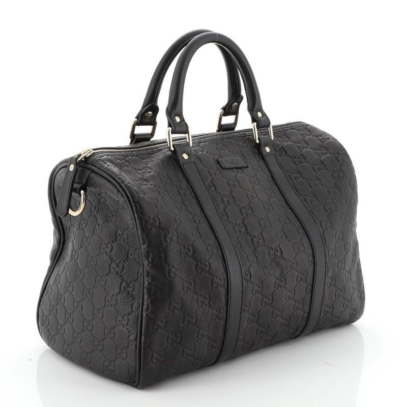 This Gucci Joy Boston Bag Guccissima Leather Medium, crafted in black Microguccissima Leather, features dual rolled handles, leather trims, and gold-tone hardware. Its top zip closure opens to a black fabric interior with zip and slip pockets.