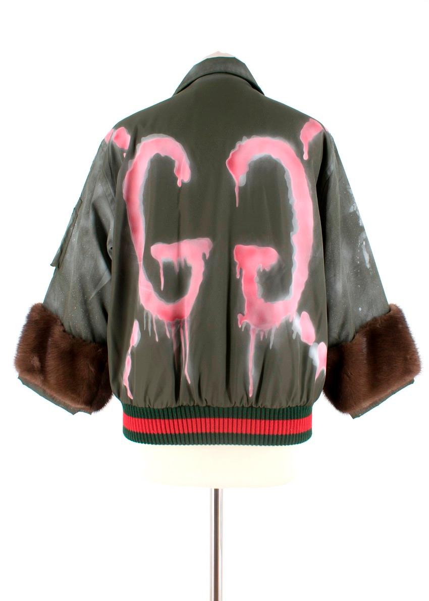 Gucci Khaki Spray Painted Bomber Jacket W/ Mink Fur Cuffs

-Mink fur cropped sleeves
-Pink GG spray paint to the back
-Khaki green body with spray paint effect
-2 working pockets in the front and a small working pocket on the sleeve -Blood orange