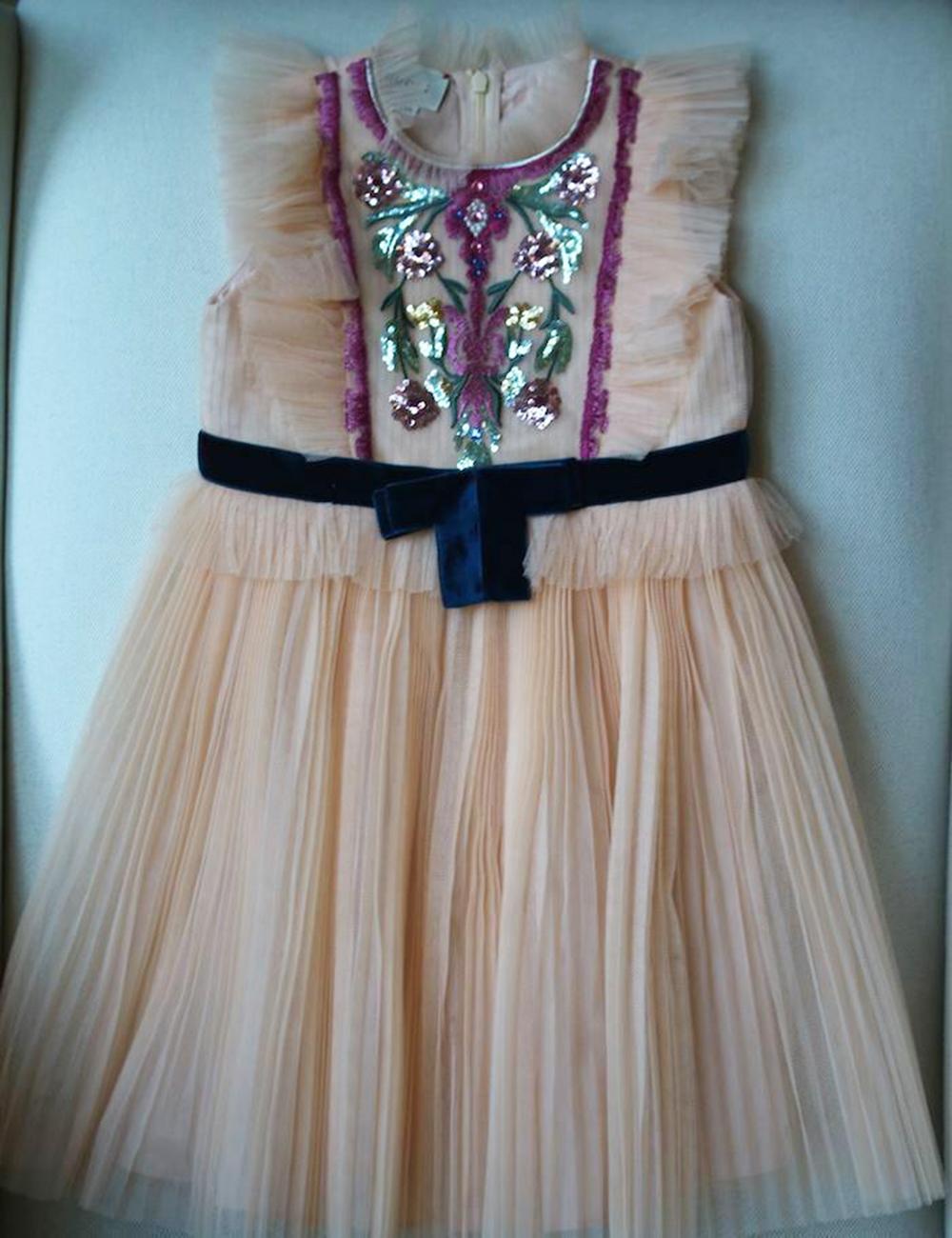 *This item is a kids dress. 

Made in pretty peach-pink tulle, this pleated dress by Gucci is luxuriously embellished with sparkly embroidery, sequins and a blue velvet waistband. This elegant design is fully lined with lightweight cotton and