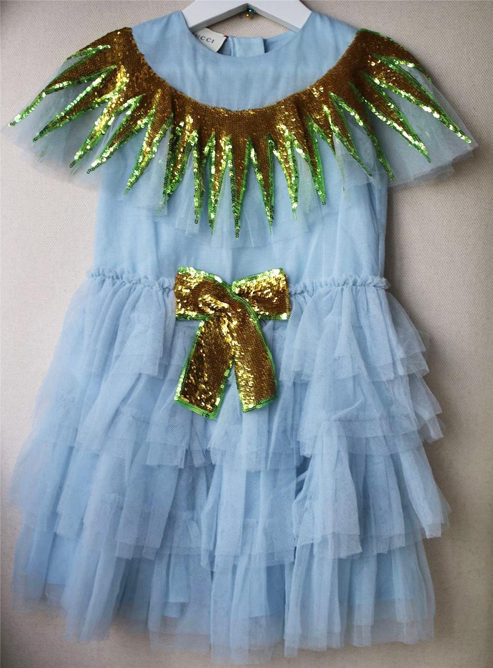 *This item is a kids dress. 

Gucci have created this striking dress for girls who like to shine. Made in delicate, twirl-worthy tiers of blue tulle, it has a glittering sequinned ruffle around the shoulders with a matching decorative bow on the