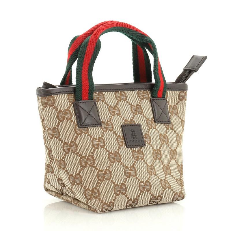 This Gucci Kid's Web Tote GG Canvas Mini, crafted in brown GG coated canvas, features dual web handles, leather trim and silver-tone hardware. It opens to a brown fabric interior with slip pocket.

Condition: Excellent. Minor wear on base corners,