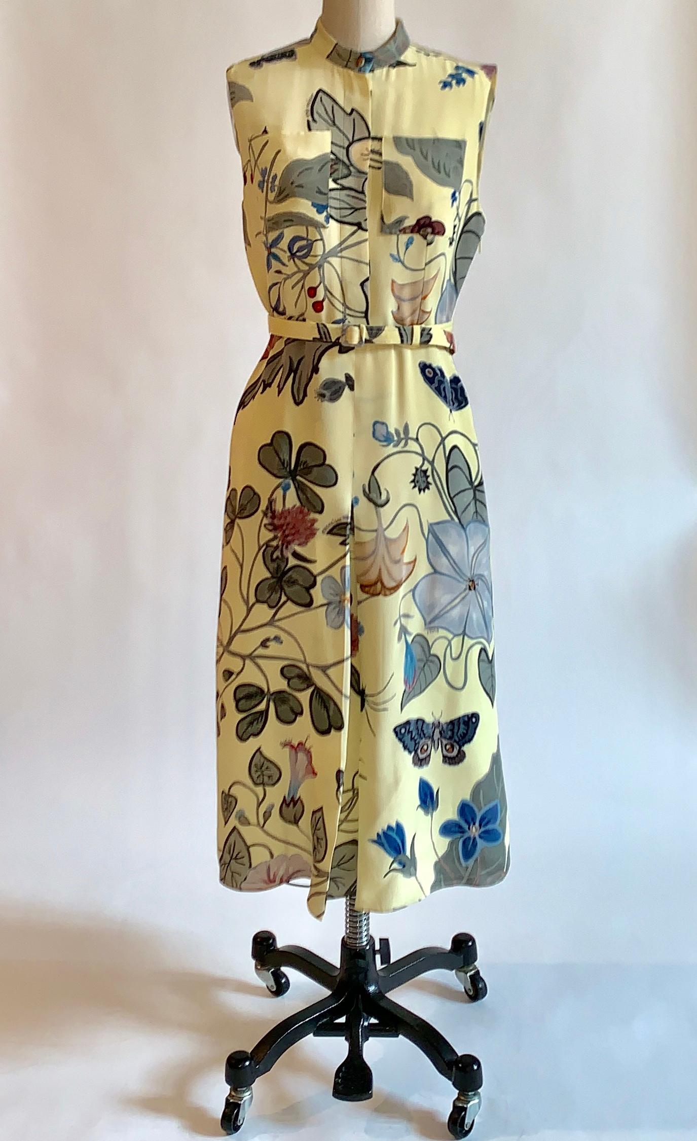 Yellow silk Gucci floral dress featuring artist Kris Knight's re-imagination of the iconic Gucci flora print. Print features insects and plants associated with ancient pagan Rome, is signed 'Kris Knight' and 'Gucci' throughout. Patch pockets at