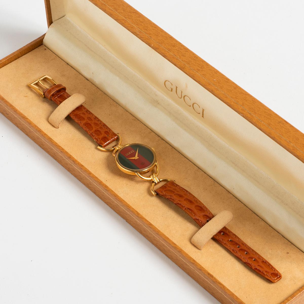 Nuestra referencia 6000 (6000L) de Gucci para mujer, inspirada en el icónico bocado de caballo vintage, tiene una caja de acero inoxidable con tapa dorada de 25 mm x 40 mm (incluida la corona y el bocado de caballo), correa original de Gucci y