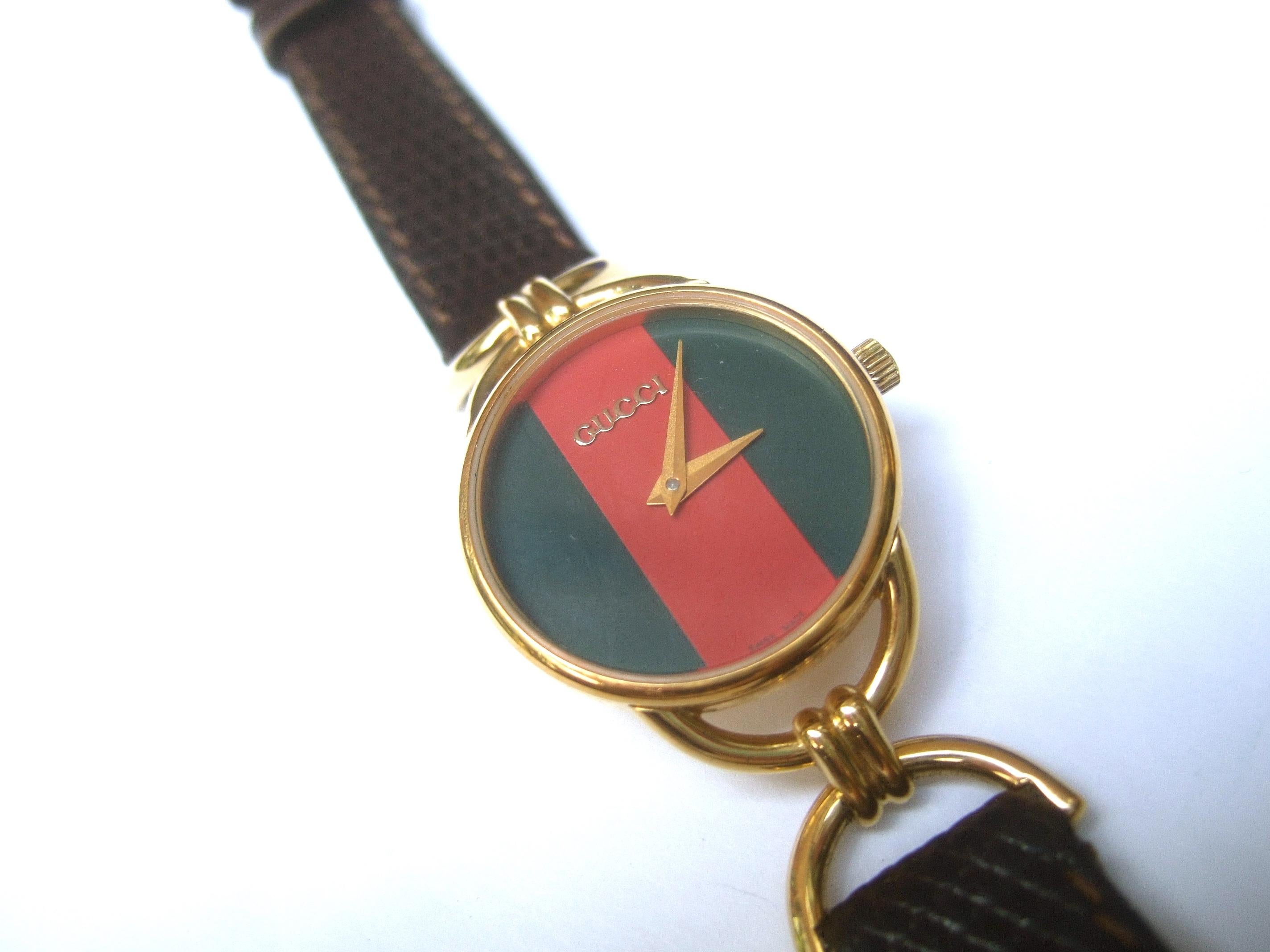 Gucci Ladies red & green striped dial wristwatch in Gucci presentation box c 1980

The elegant Gucci watch circular dial is framed with sleek gilt metal signed Gucci Swiss Made. The watch dial is paired with an embossed brown leather thin strap.