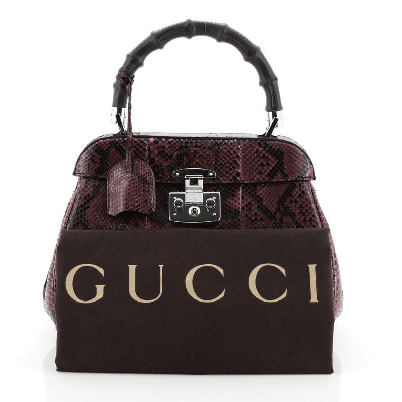 This Gucci Lady Lock Bamboo Top Handle Bag Python Medium, crafted in genuine purple python, features a single loop bamboo handle and silver-tone hardware. Its flap with lady lock closure opens to a purple microfiber interior divided into two