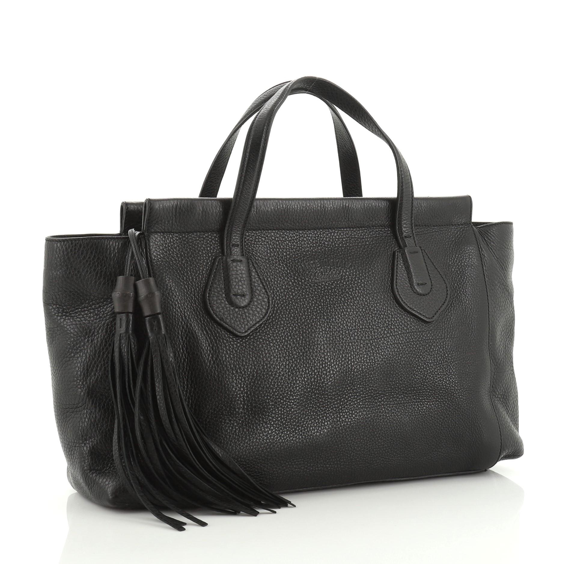 This Gucci Lady Tassel Top Handle Bag Leather Medium, crafted from black leather, features dual tall flat handles, soft framed top, and gold-tone hardware. Its top zip closure opens to a neutral leather interior with side zip and slip pockets.