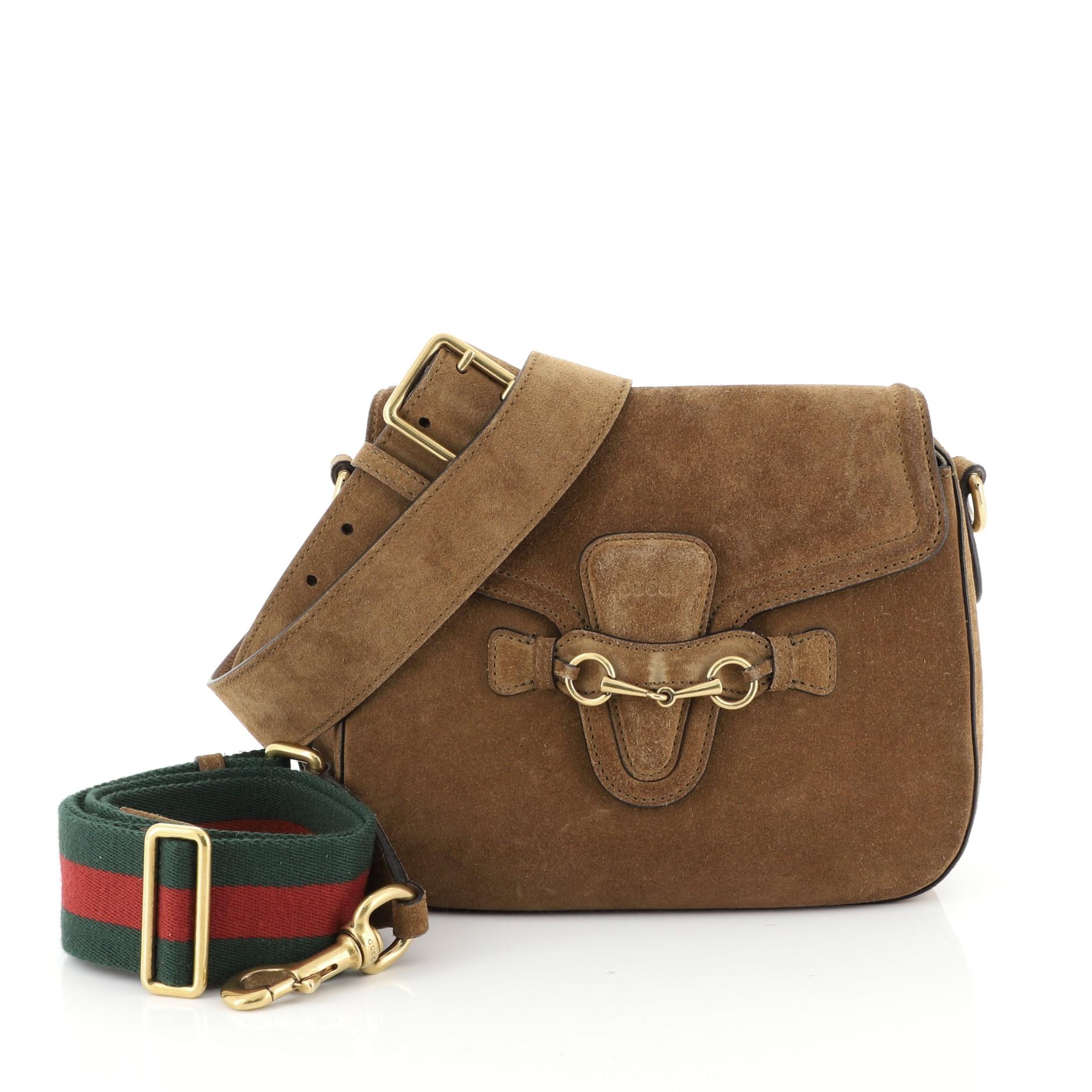 This Gucci Lady Web Shoulder Bag Suede Medium, crafted from brown suede, features an adjustable shoulder strap and gold-tone hardware. Its flap closure with horsebit buckle detail opens to a neutral suede interior. 

Estimated Retail Price:
