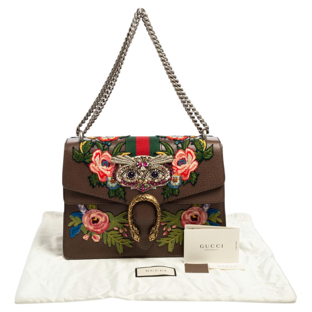 This Gucci creation has been beautifully crafted from leather in a brown shade. The exterior is adorned with floral embroidery, owl embellishment, and the flap carries tiger heads with reference to the Greek god, Dionysus and it secures canvas