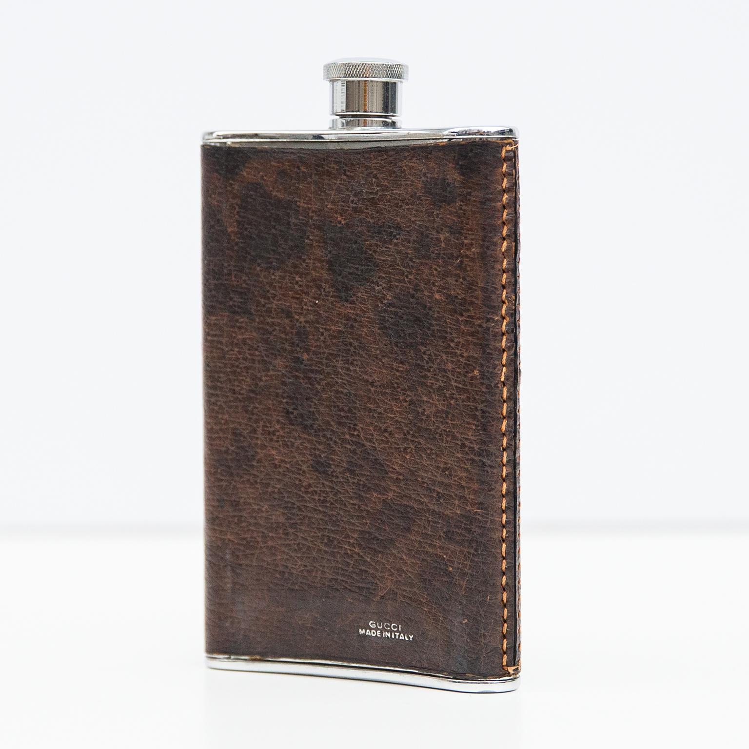 Silver plated hip flask designed in leather and engraved Gucci on the bottom.