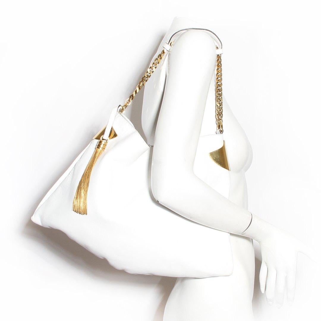 Leather hobo bag by gucci
White leather
Snap closure top
Two slip pockets
One zip pocket 
Goldtone hardware 
Gold tassle
Condition: Excellent condition, some marks on outer edges and bottom of bag, some scratching on leather and hardware. Wear