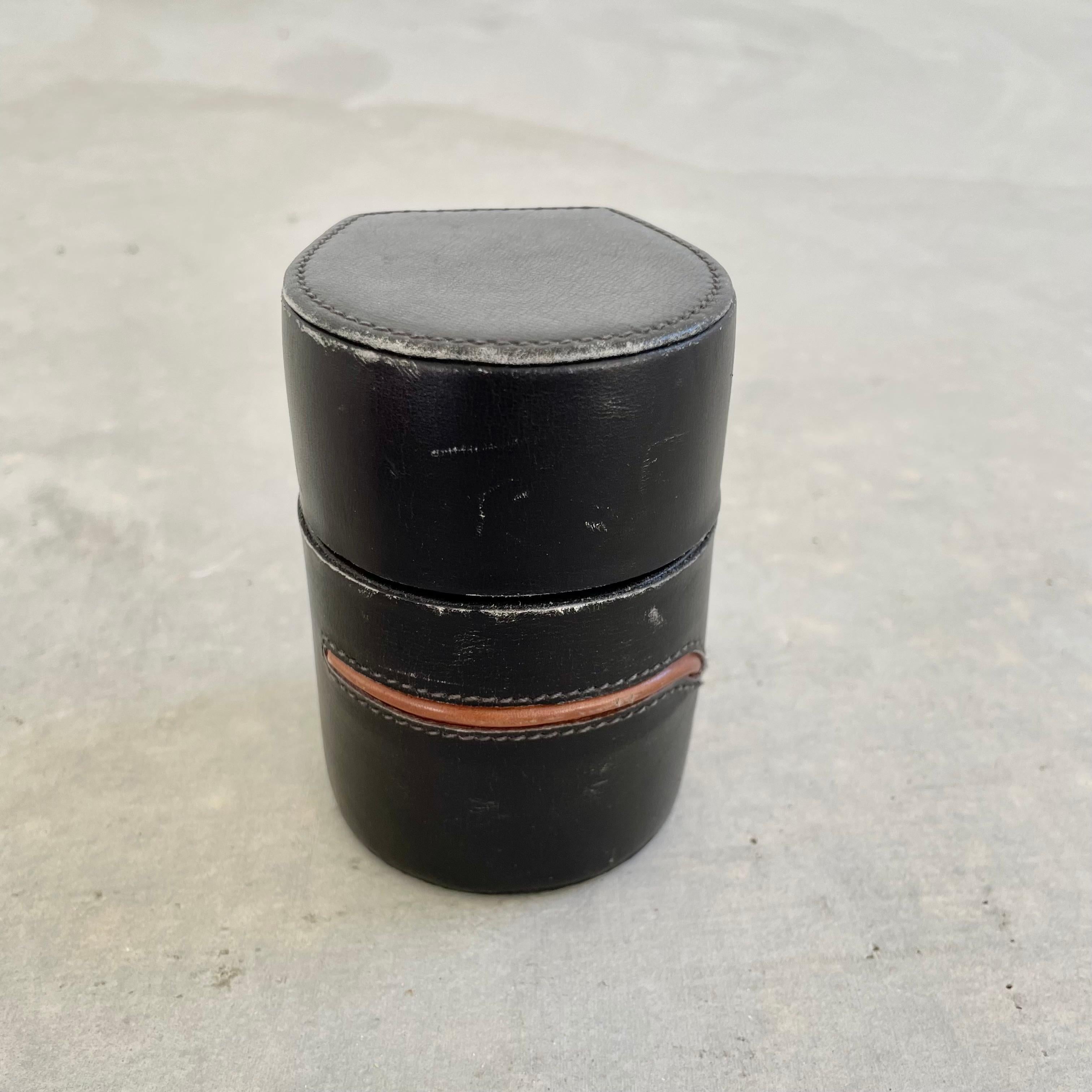 Elegant and rare Gucci table lighter with great details. Completely wrapped in black leather with one brown leather strip stitched onto the face of the lighter. The base is a black suede with a stamp reading 