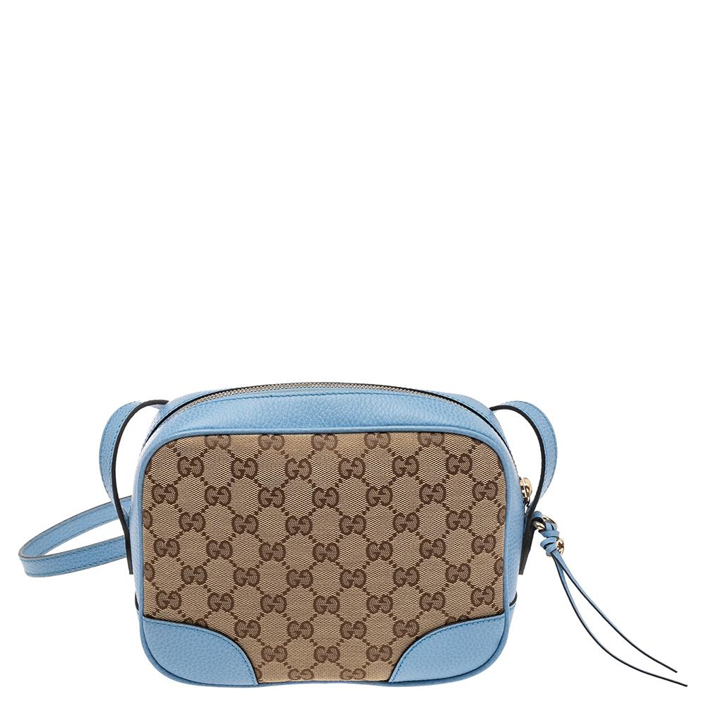 This blue and beige bag from Gucci is stylish and functional. Crafted from the signature GG canvas and leather, it features a top zip closure that opens to a canvas-lined interior housing an open compartment, a slip pocket, and multiple card slots.