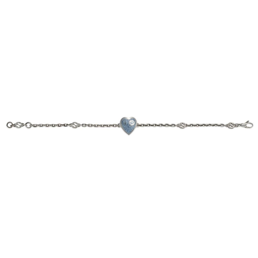 An intricate woven link chain style bracelet in sterling silver made by Gucci. This bracelet features an easy to use clasp style closure with a light blue enamel with silver interlocking G stencil engraved on this enamel.