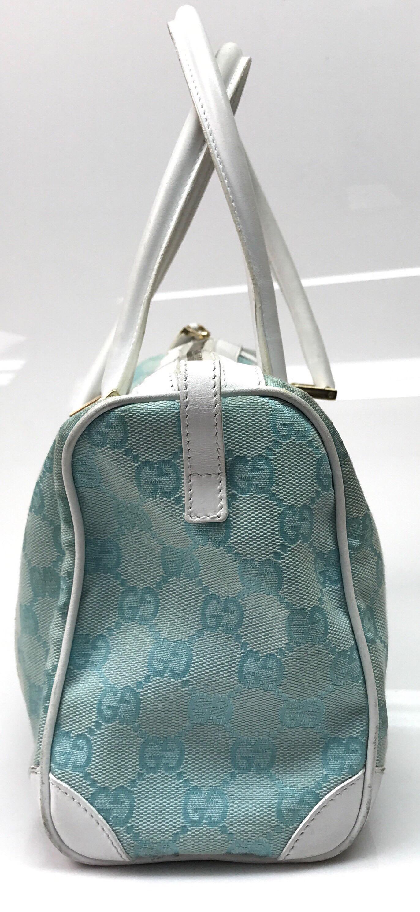 Gucci Light Blue & White Monogram Speedy Handbag. This adorable Gucci handbag is in good condition. It shows some sign of use with discoloration or fading of the monogrammed material along with some small cracking of the white leather, as shown is