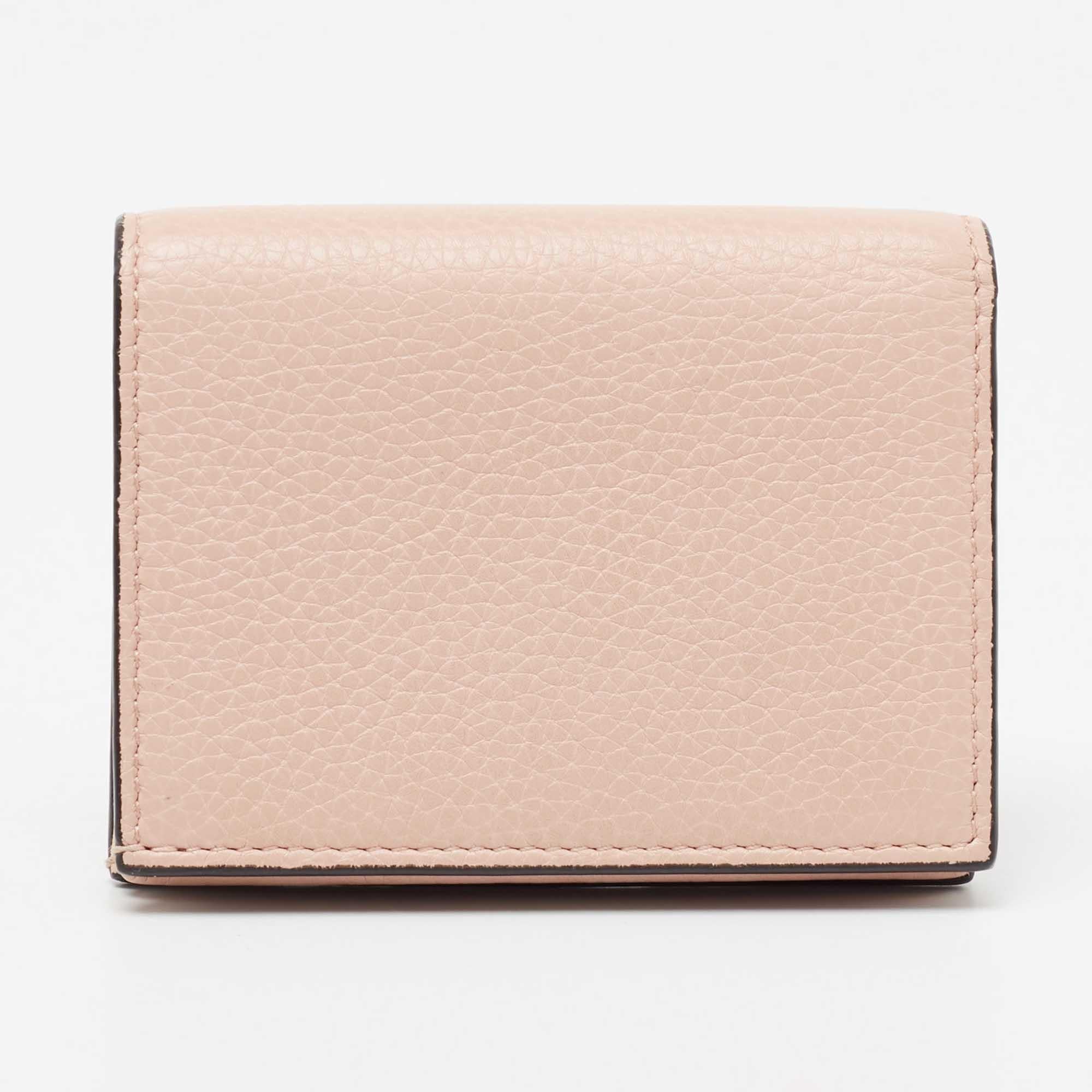 This 'Blind for Love' card case from Gucci is a stylish creation that is exceptionally well-made. Crafted from light-pink leather, this case is embellished beautifully with a gold-toned inscription and Bee motif on the front. It unveils a