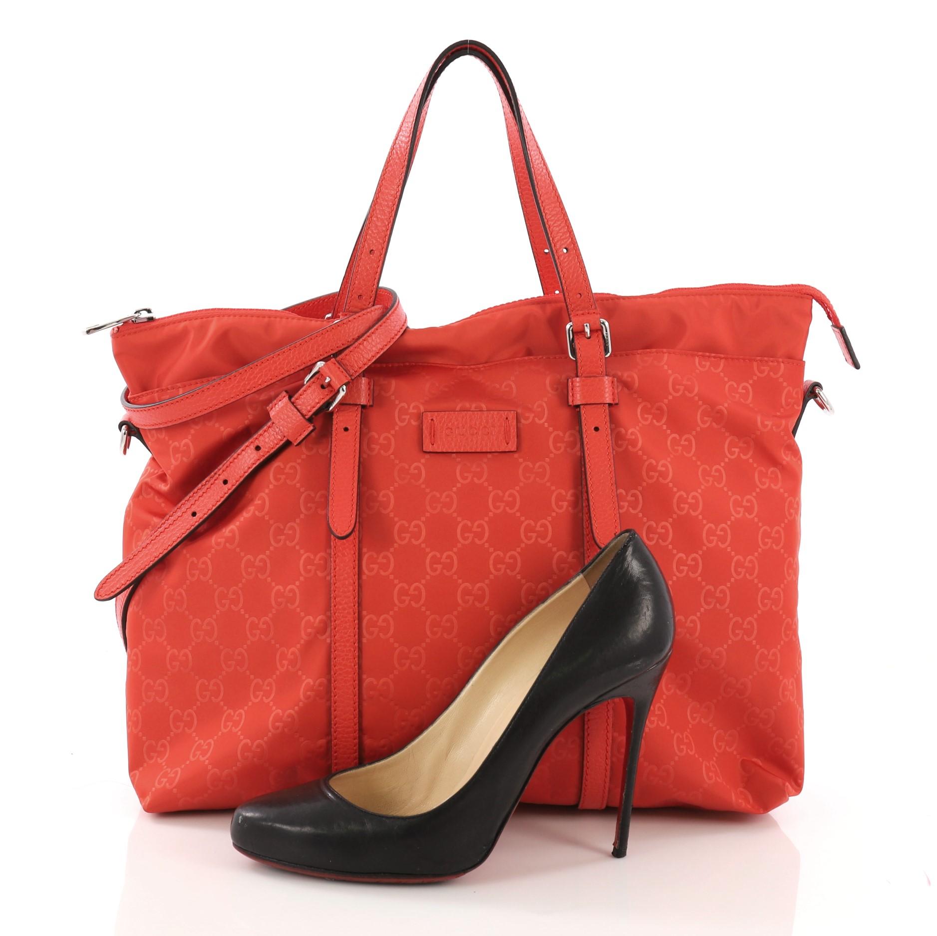 This Gucci Light Tote Guccissima Nylon Medium, crafted in red guccissima nylon, features dual slim handles and silver-tone hardware. Its zip closure opens to a red nylon interior with side zip and slip pockets. **Note: Shoe photographed is used as a