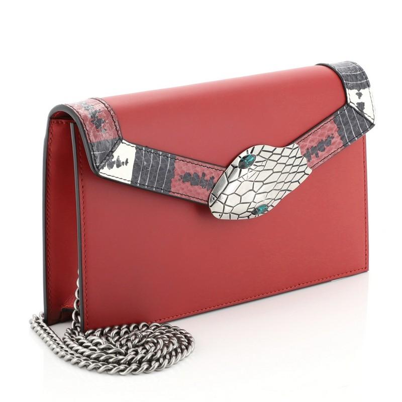This Gucci Lilith Flap Shoulder Bag Leather with Snakeskin Small, crafted in red leather, features chain-link strap, genuine snakeskin detail along the flap, Kingsnake closure, and aged-silver-tone hardware. Its push-lock closure opens to a brown