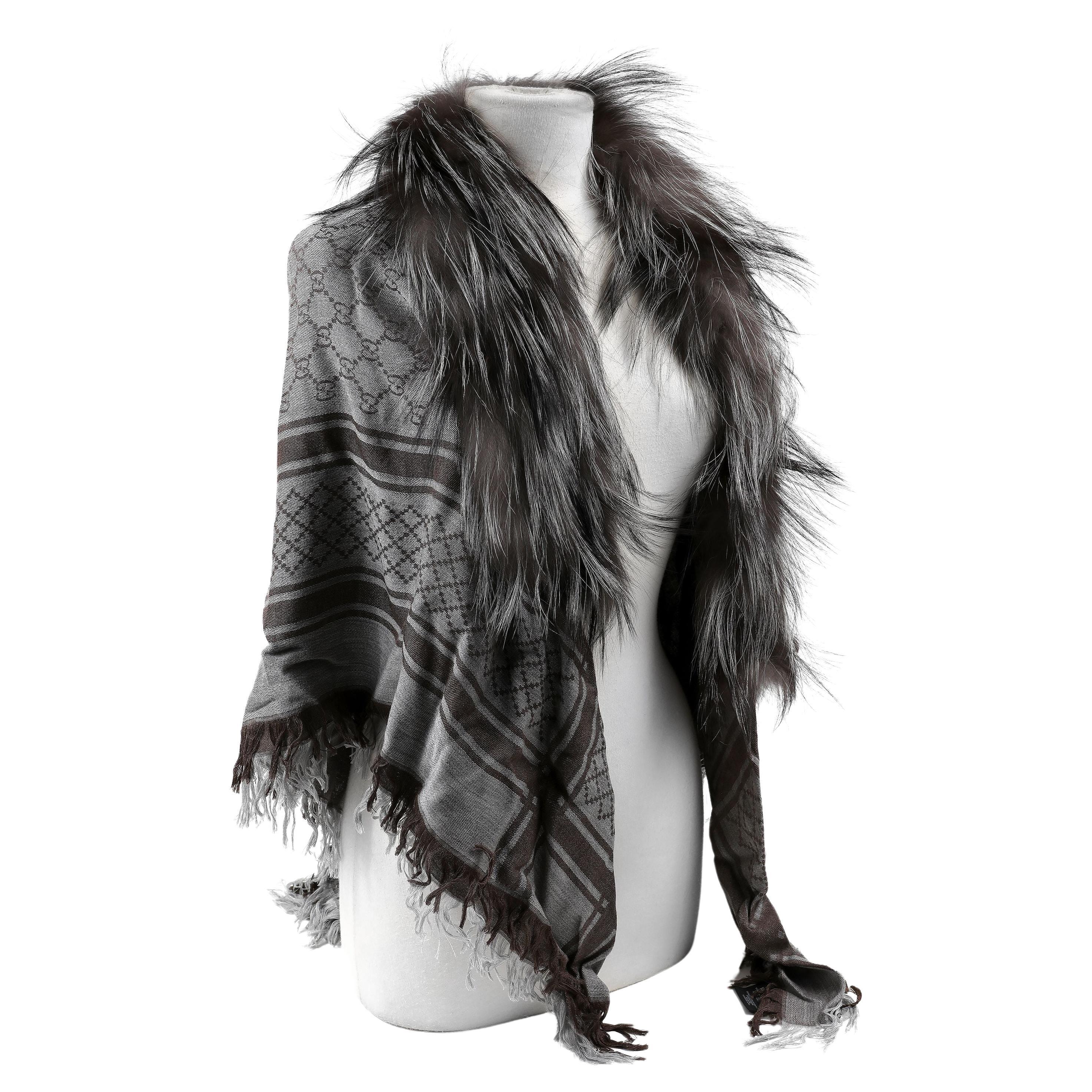 This authentic Gucci Grey Fox Fur Trim Shawl is brand new.  Limited Release.  Grey monogram shawl/ scarf with grey fox fur trim.  Tag attached.  
ACO 13811
