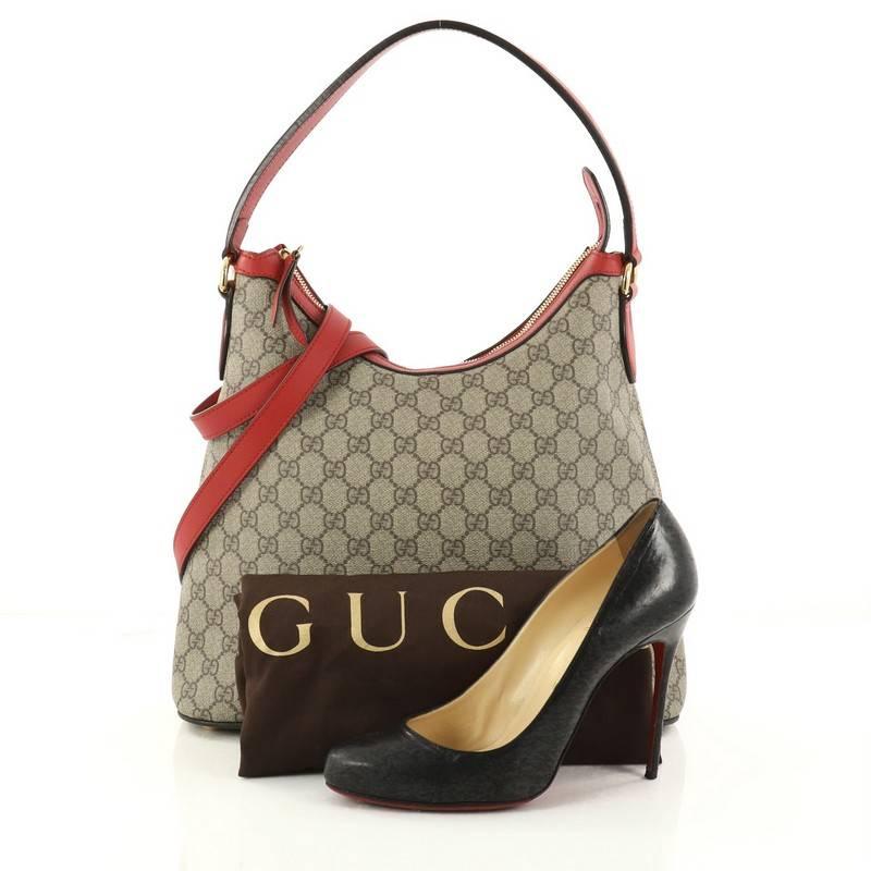 This authentic Gucci Linea A Hobo GG Coated Canvas is an elegant bag perfect for everyday casual looks. Crafted in brown GG supreme coated canvas, this structured bag features curved top handle, detachable strap, red leather trims, exterior back