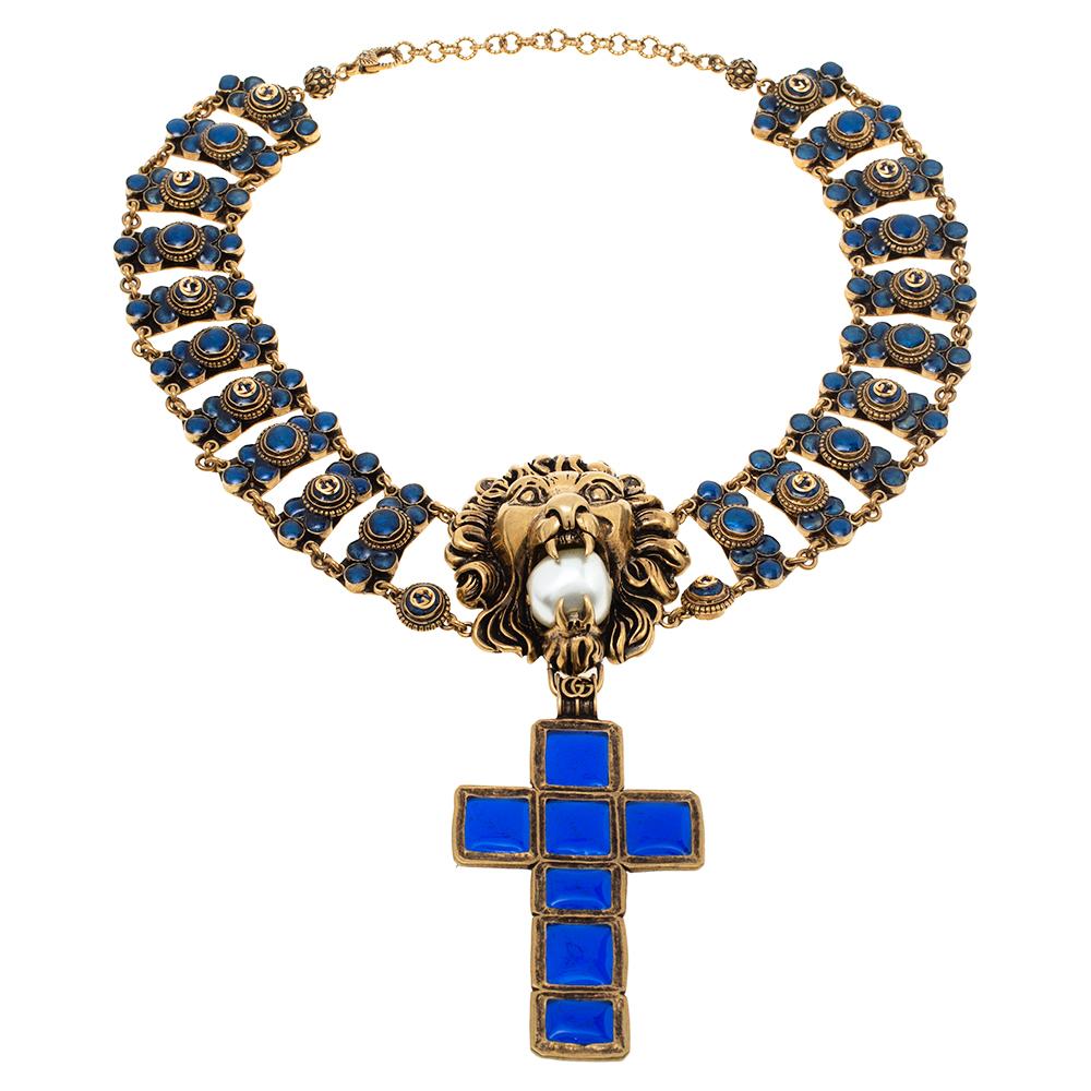 Brimming with signature elements and statement-making details, this necklace is extravagance presented in Gucci style. Beautifully-designed in antique gold-tone metal with blue inlays, the necklace holds a tiger head at the center with a faux pearl