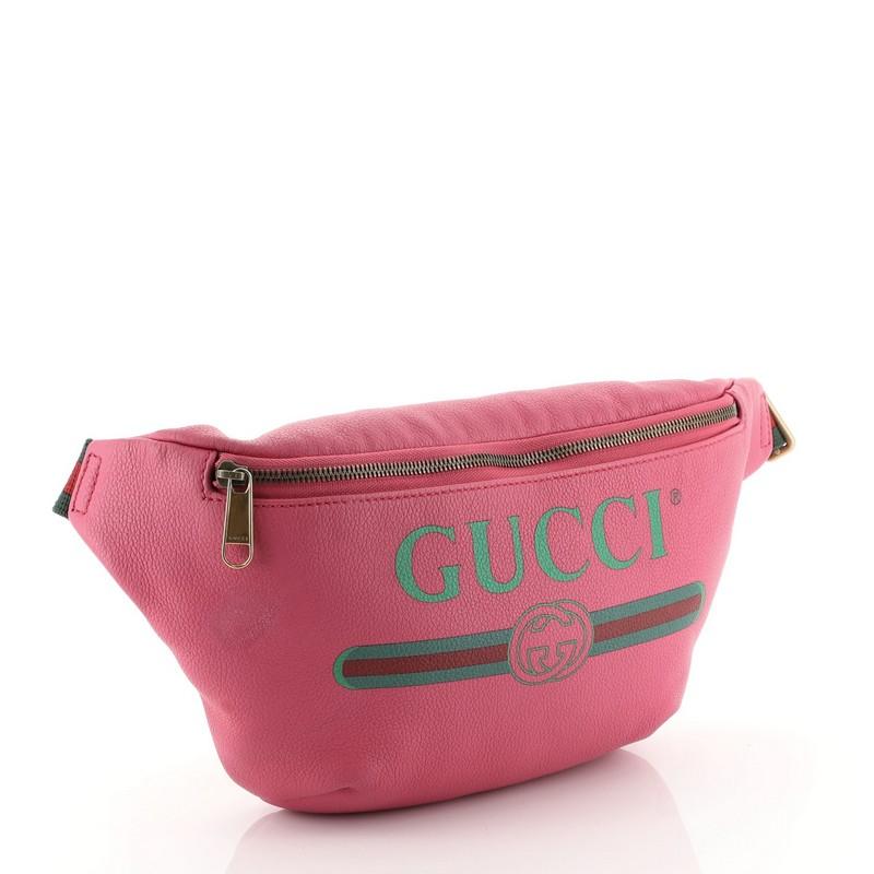 This Gucci Logo Belt Bag Printed Leather Medium, crafted in pink printed leather, features adjustable nylon web strap with buckle closure, Gucci vintage logo print, and aged gold-tone hardware. Its zip closure opens to a neutral fabric interior.