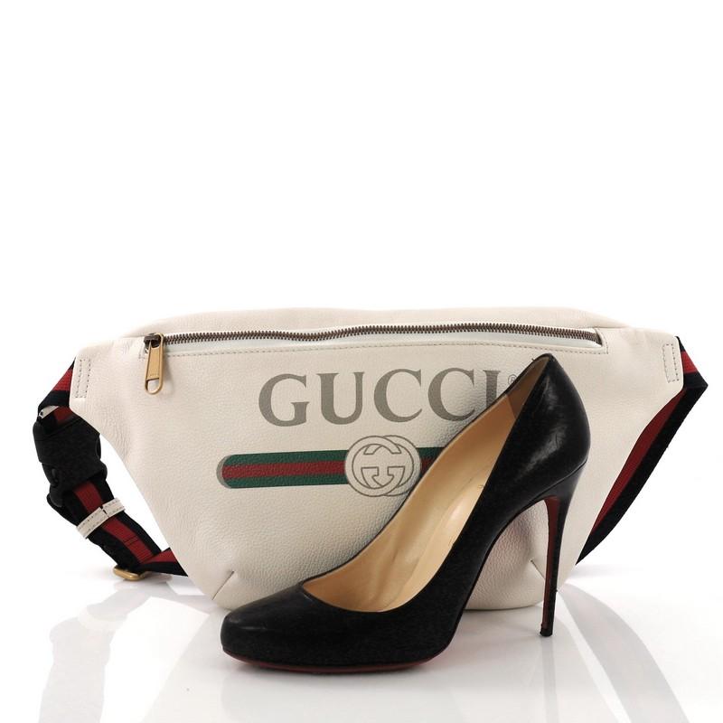 This Gucci Logo Belt Bag Printed Leather Small, crafted in off-white leather, features adjustable nylon web strap with plastic buckle closure, Gucci vintage logo, and aged gold-tone hardware. Its zip closure opens to a beige fabric interior. **Note: