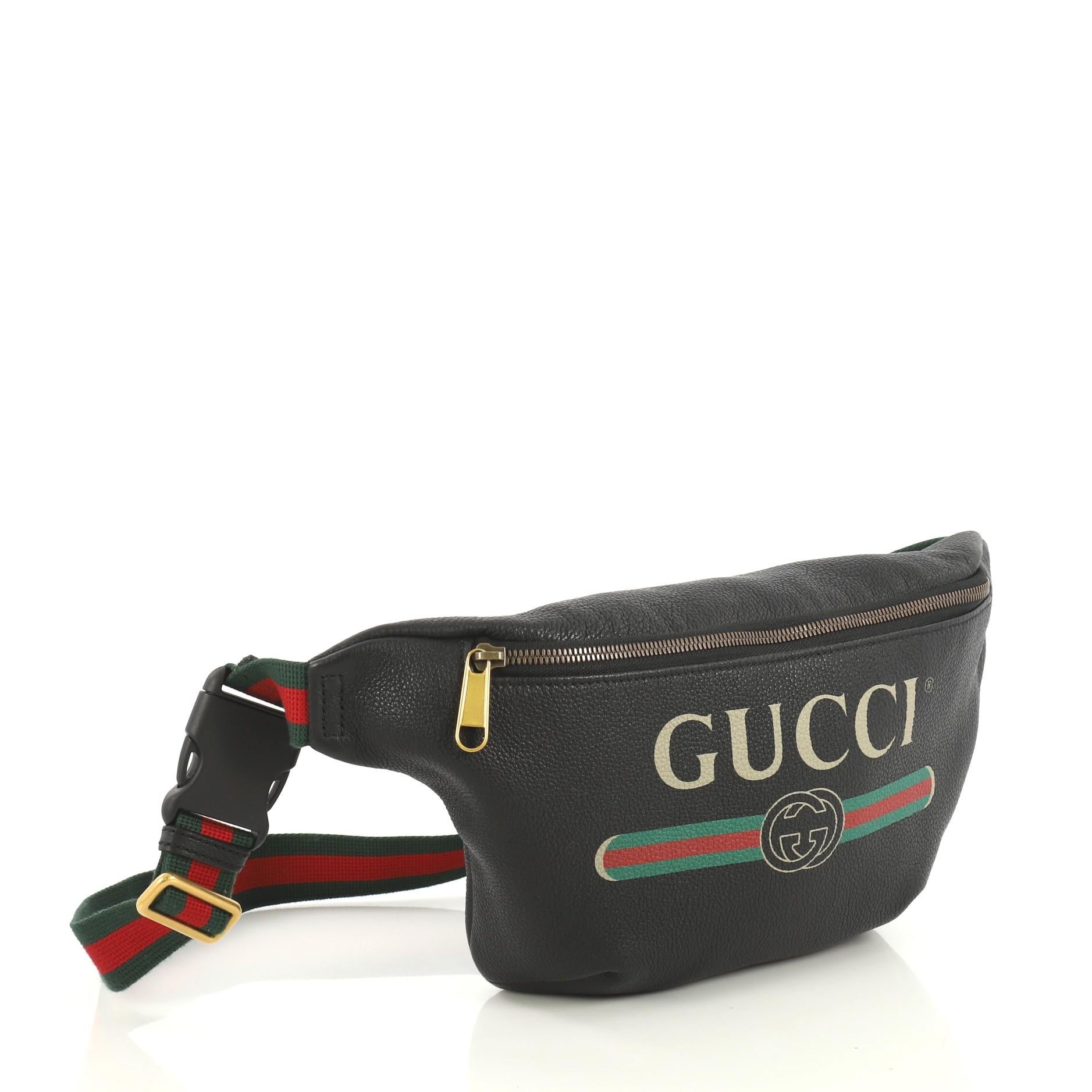 This Gucci Logo Belt Bag Printed Leather Small, crafted in black printed leather, features adjustable nylon web strap with plastic buckle closure, Gucci vintage logo, and aged gold-tone hardware. Its zip closure opens to a neutral fabric interior.