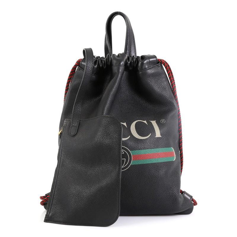 This Gucci Logo Drawstring Backpack Printed Leather Medium, crafted in black printed leather, features dual leather top handles, rope straps that double function as a drawstring, and aged gold-tone hardware. Its drawstring closure opens to a black