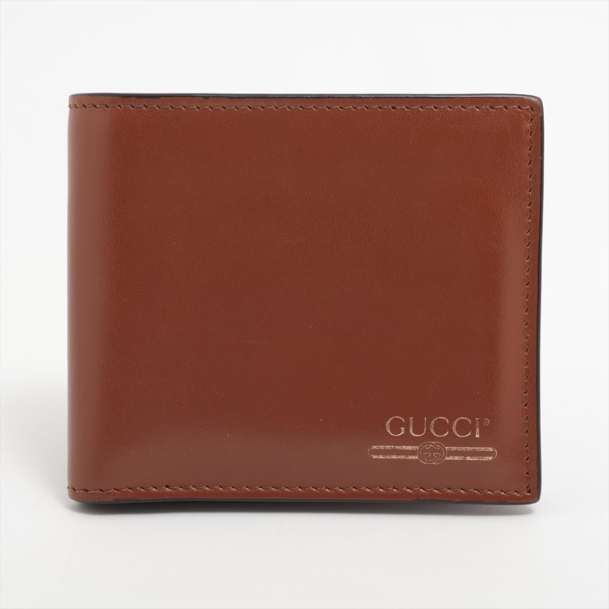 The Gucci Logo Leather Bi-fold Compact Wallet in Brown is a sophisticated accessory that combines elegance with practicality. Crafted from premium brown leather, the wallet exudes timeless charm and durability. The front is adorned with the iconic