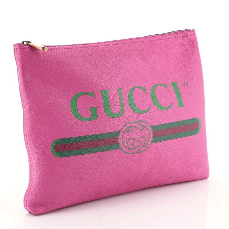 This Gucci Logo Portfolio Clutch Printed Leather Medium, crafted from pink leather, features printed Gucci logo and aged gold-tone hardware. Its zip closure opens to a pink suede interior. 

Estimated Retail Price: $950
Condition: Fair. Wear on base