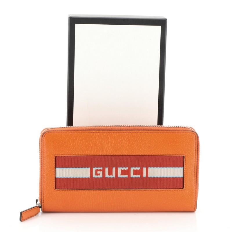 This Gucci Logo Zip Around Wallet Leather Long, crafted in orange leather, features Gucci vintage logo at front and silver-tone hardware. Its zip-around closure opens to an orange leather and brown nylon interior with multiple card slots, center zip
