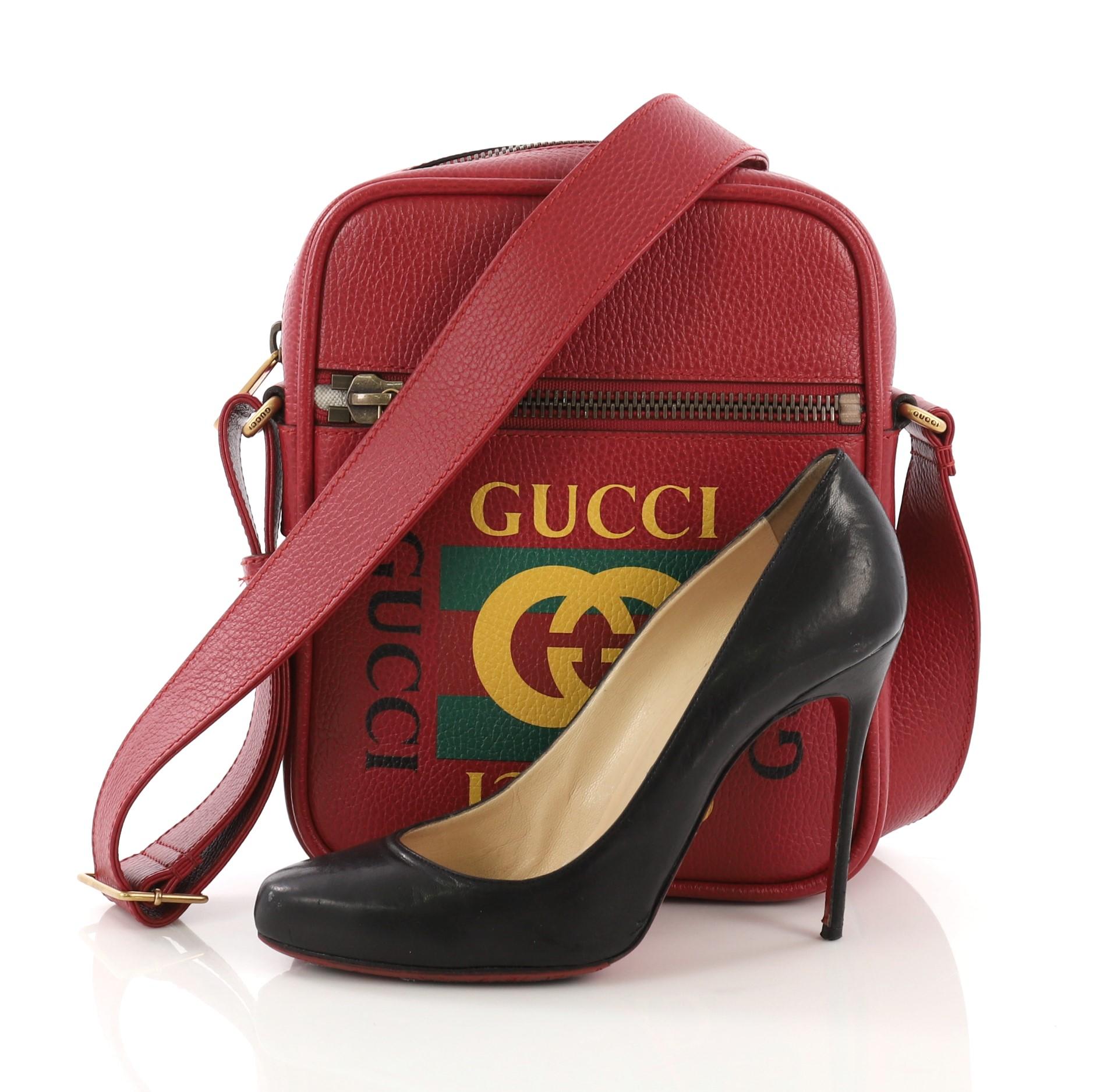 This Gucci Logo Zip Messenger Bag Printed Leather Small, crafted from red printed leather, features adjustable leather strap, front zip pocket, printed Gucci vintage logo, and aged gold-tone hardware. Its top zip closure opens to a beige fabric