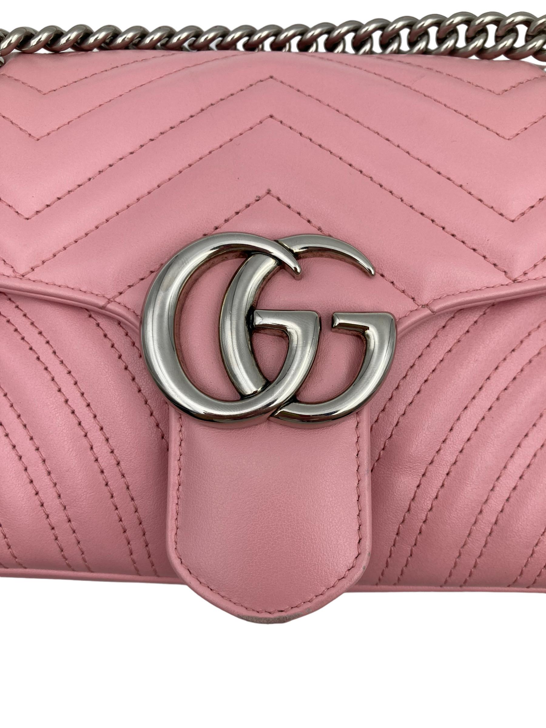 Borsa firmata Gucci, linea Marmont, misura 26, realizzata in pelle matelassè rosa con hardware dorati. Dotata di una patta frontale con chiusura a incastro e logo ”GG”. Munita di una tracolla a scorrimento realizzata in catena a maglia larga e