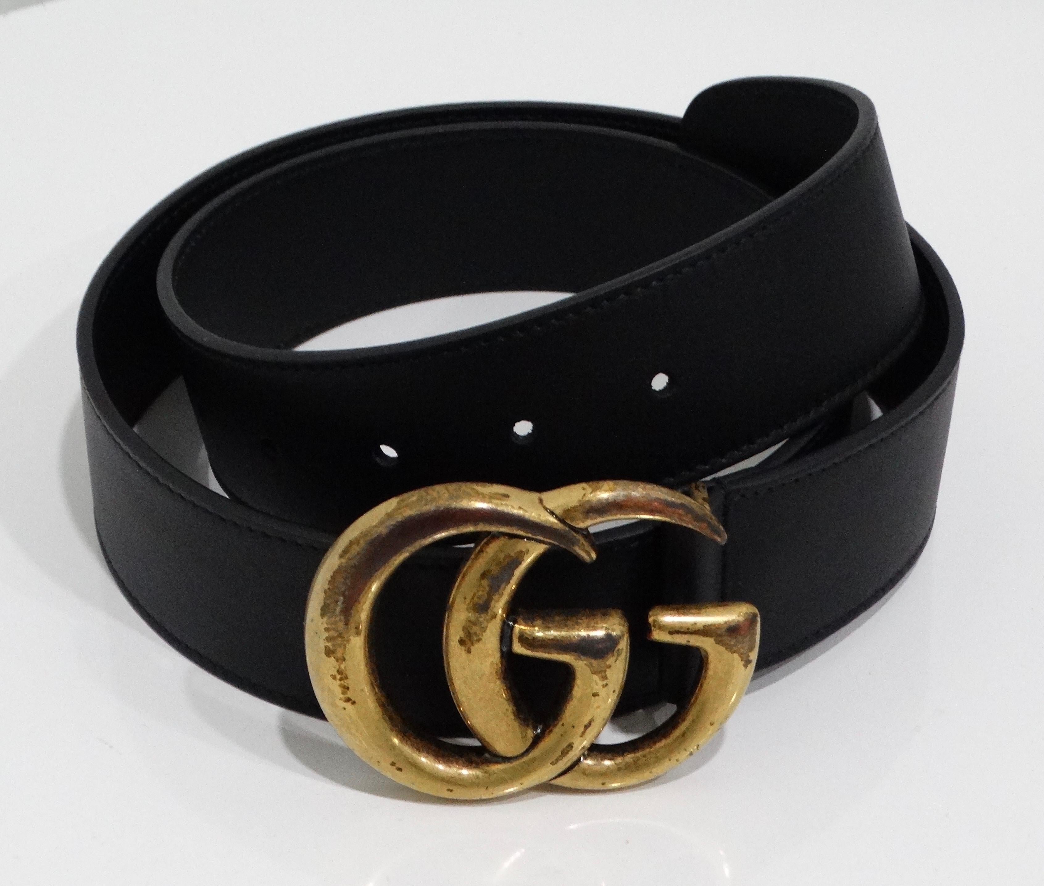 Introducing the Gucci Marmont Belt, an embodiment of luxury and timeless style. Crafted from genuine black leather, this exquisite accessory features the iconic GG logo buckle in antique brass, adding a touch of sophistication to any outfit. The