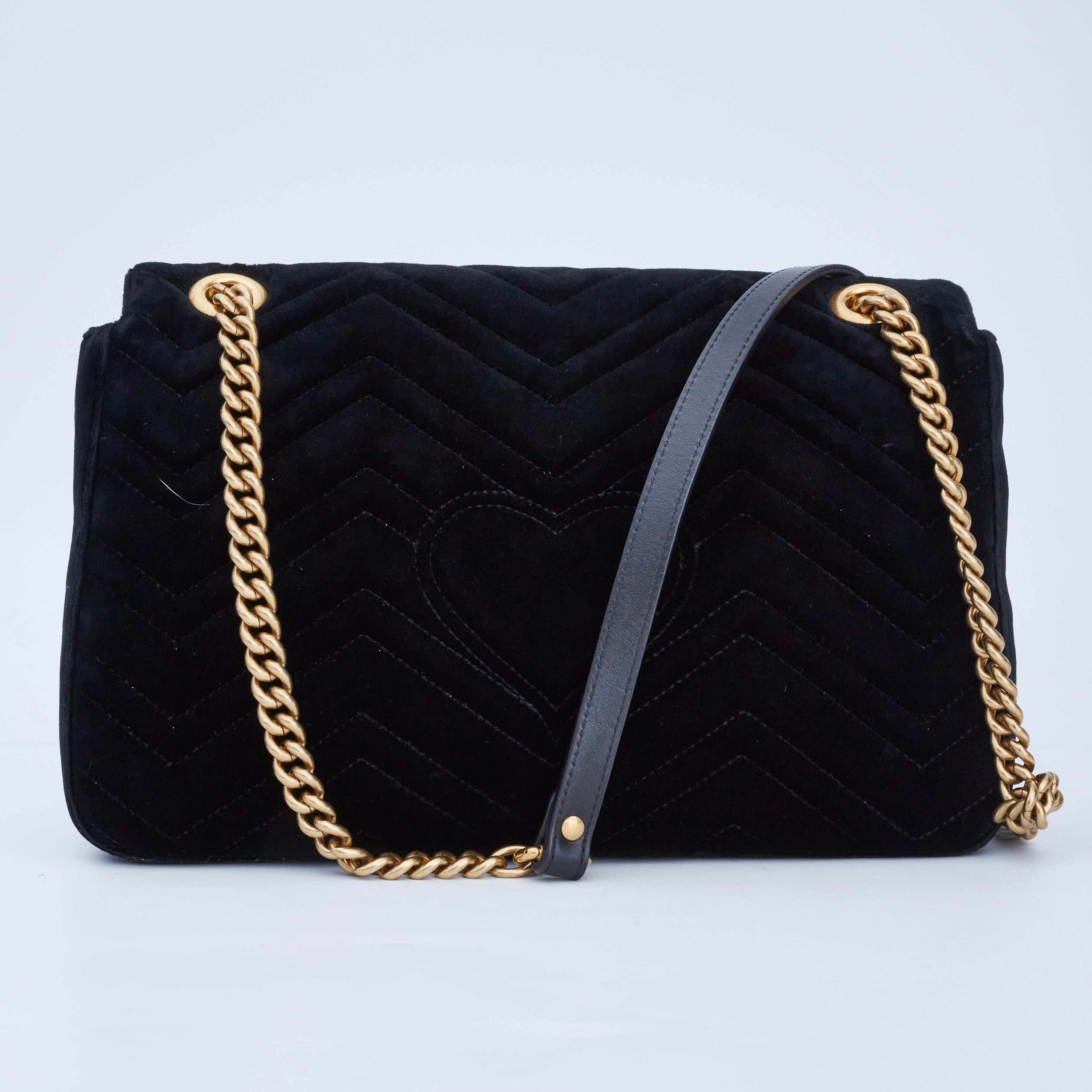 This shoulder bag is made of soft velvet in black. This bag features eye-catching embroidery lined with faux pearls spelling the word LOVED with two flowers and a long aged-gold chain-link shoulder strap with a leather shoulder pad. The front