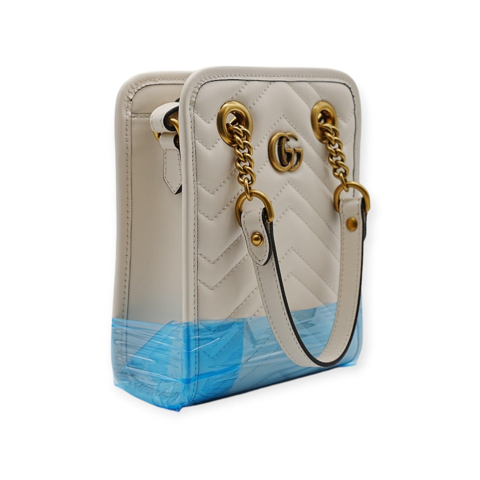 The Gucci Marmont Matelassè Quilted Mini Bag is a chic vertical tote crafted from white quilted leather. With its distinctive GG logo and structured design, it combines elegance and functionality, making it a perfect accessory for any occasion.
