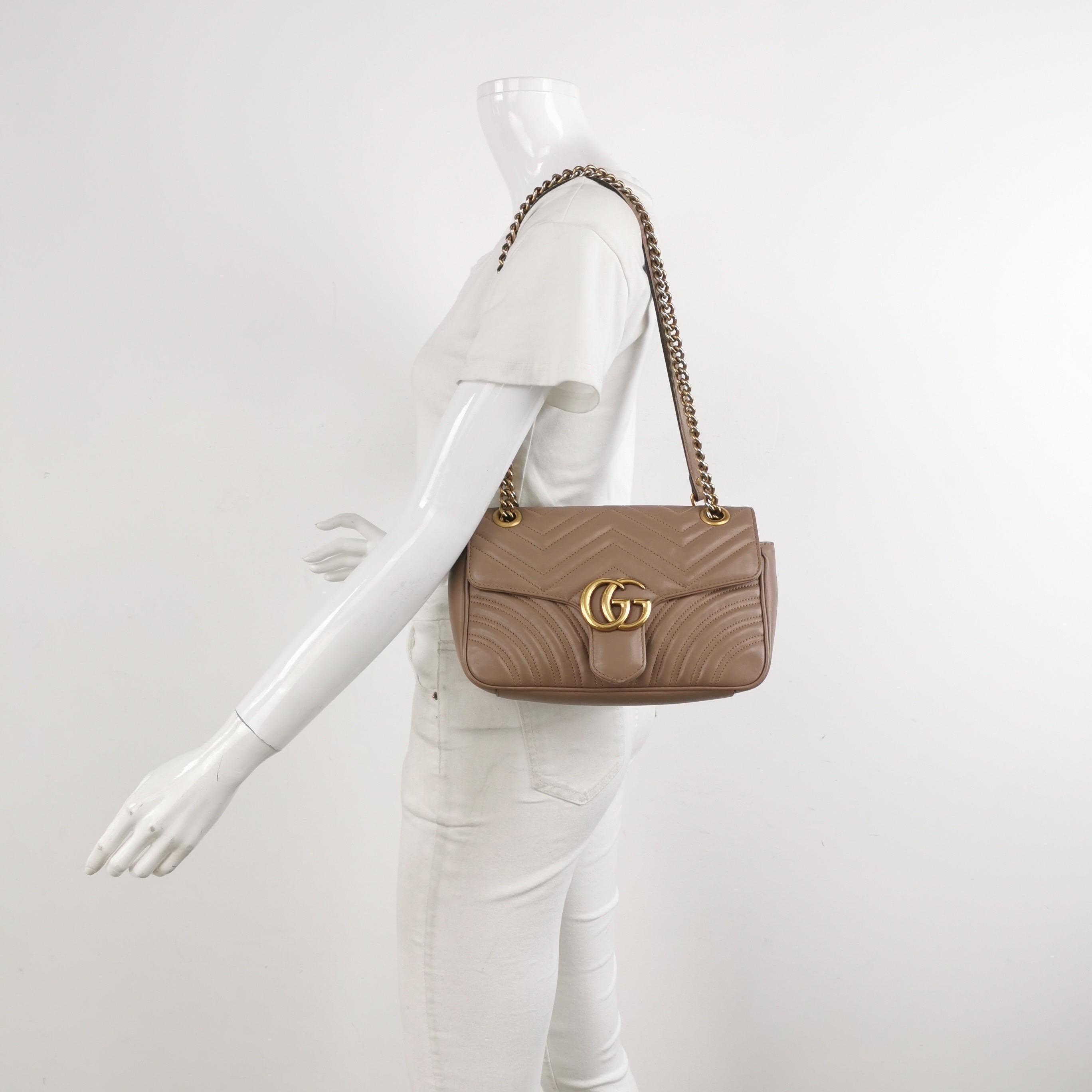 La borsa Gucci Marmont Mini Flap Crossbody è un accessorio senza tempo e adattabile progettato dal famoso marchio Gucci. Le cuciture chevron a forma di V e il logo GG in evidenza sull'apertura della patta la rendono immediatamente riconoscibile. La