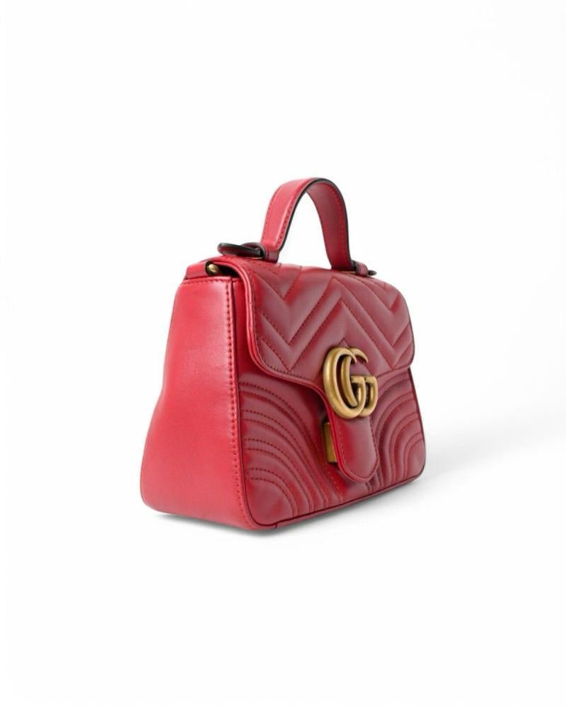 Gucci signature bag, Marmont line, made of leather in the red coloring with matelassé pattern and gold hardware. Features a front flap with classic gold metal 