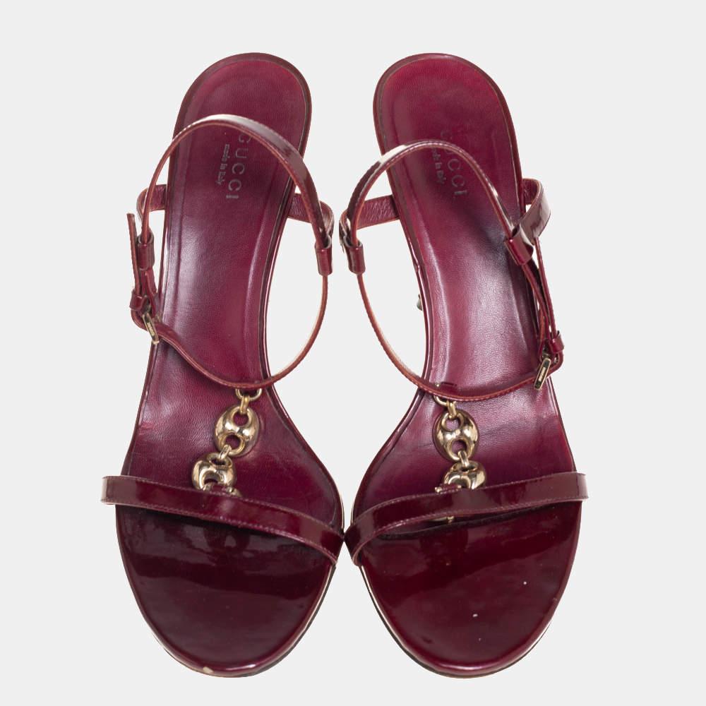 How can one not fall in love with these stunning sandals by Gucci! They've been beautifully crafted from maroon patent leather and styled with gold-tone chain T-straps on the vamps. The sandals carry open toes, ankle straps with buckle fastening,