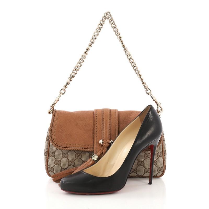 This Gucci Marrakech Convertible Evening Bag Leather and GG Canvas, crafted from brown leather and beige GG canvas, features chain link shoulder strap, front flap with braided leather bow and tassel accents, braided leather trim, and gold-tone