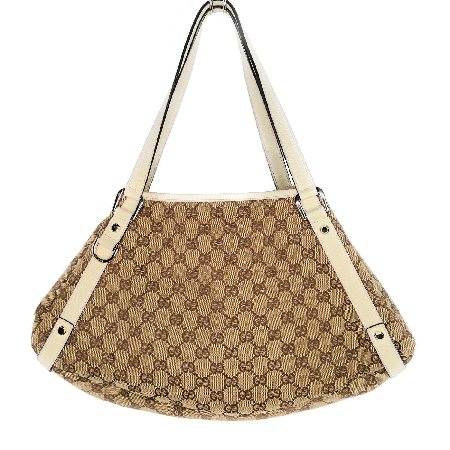 This chic hobo is crafted of Gucci GG monogram canvas and features double looping leather shoulder straps with light gold hardware links. The top is open to a brown fabric interior with zipper and patch pockets.

Designer: Gucci
Material: