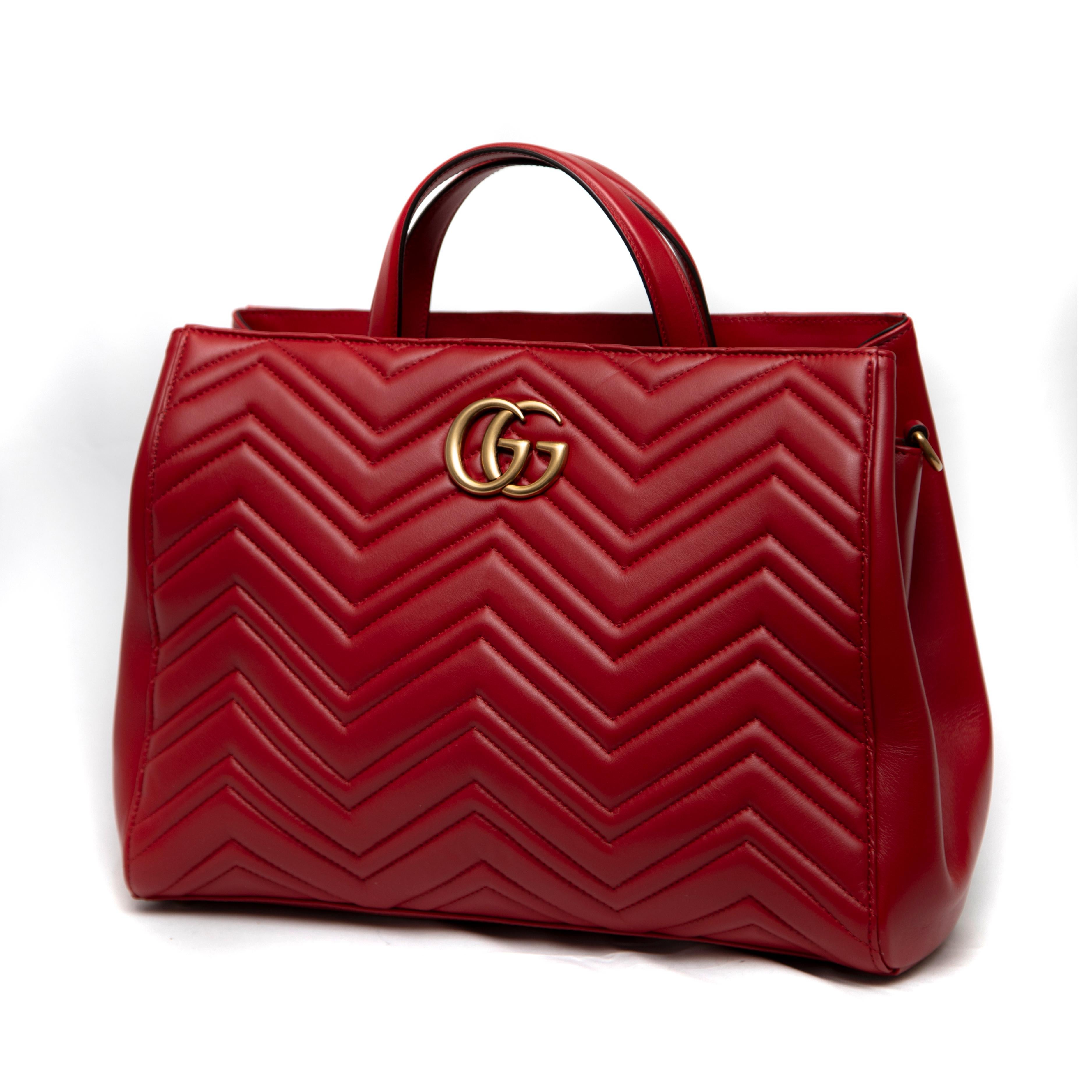 The Medium Red G Marmont Matelassé Tote Bag is a stunning embodiment of Gucci's craftsmanship and iconic design. Made from luxurious matelassé leather, this bag features a beautifully quilted pattern that adds depth and sophistication to its